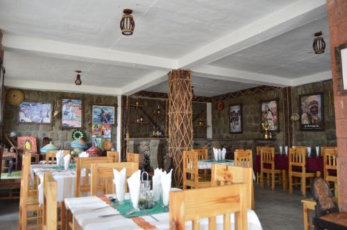 拉利贝拉Zan-Seyoum Hotel - Lalibela的一间在房间内配有桌椅的餐厅