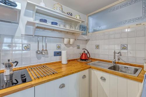 克拉斯Holiday House Mlin的厨房配有白色橱柜和水槽
