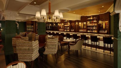纽卡斯尔Slieve Donard的餐厅设有酒吧,提供椅子和葡萄酒瓶