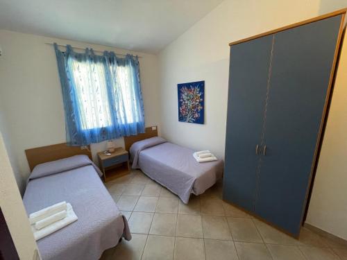 维拉普特祖Residence Il Borgo di Porto Corallo的小房间设有两张床和一扇门