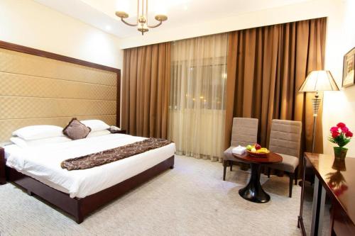 迪拜Better Living Apartment的酒店客房,配有床、桌子和椅子