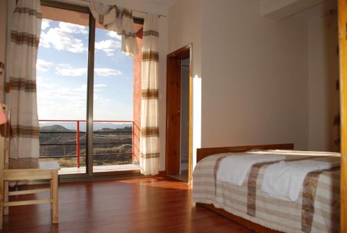 拉利贝拉Zan-Seyoum Hotel - Lalibela的一间卧室设有一张床和一个大窗户