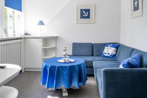 威克奥夫弗尔阿尔福斯藤岛上酒店的客厅配有蓝色的沙发和桌子