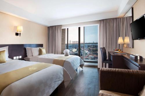 雅加达赫维贝斯韦斯特精品酒店的酒店客房设有两张床和窗户。