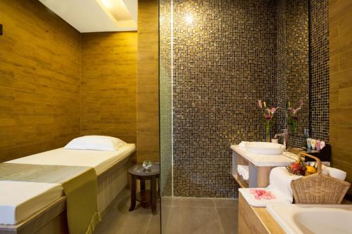 雅加达赫维贝斯韦斯特精品酒店的一间带床、浴缸和水槽的浴室