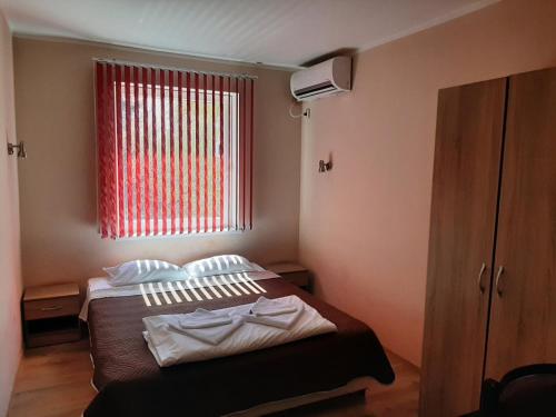 Cherven BryagХотел Таганрог的一间卧室设有一张床和一个红色的窗户
