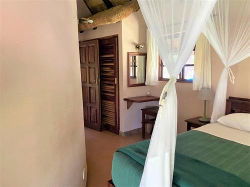 布拉瓦约Twin bed lodge on natural African bush - 2111的一间卧室配有白色窗帘的床
