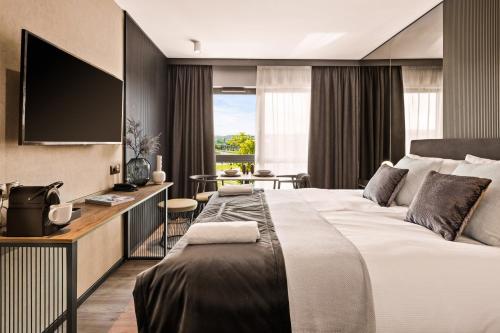 格但斯克Royal Apartments - Boutique Residence Gdańsk的酒店客房配有一张床和一张书桌及一台电视