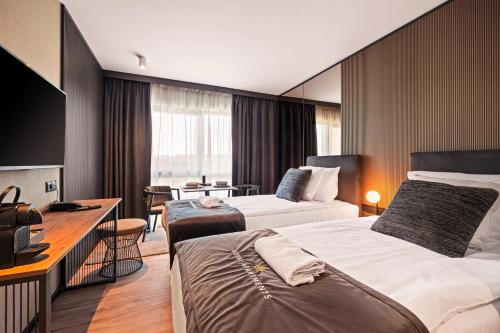 格但斯克Royal Apartments - Boutique Residence Gdańsk的酒店客房配有两张床和一张书桌