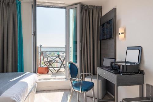 凡尔赛凡尔赛大厦酒店的配有一张床、一张书桌和一扇窗户的酒店客房