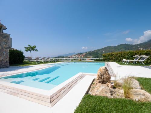 皮特拉利古Agriturismo Terre degli Angeli的一座位于别墅内的游泳池,别墅的背景是群山