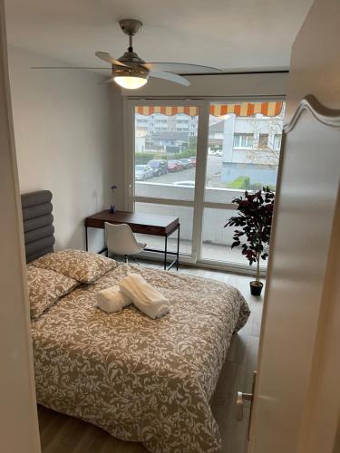 RhutLe mûrier - 2 chambres chez l'habitant的一间卧室配有一张床、一张桌子和一个窗户。