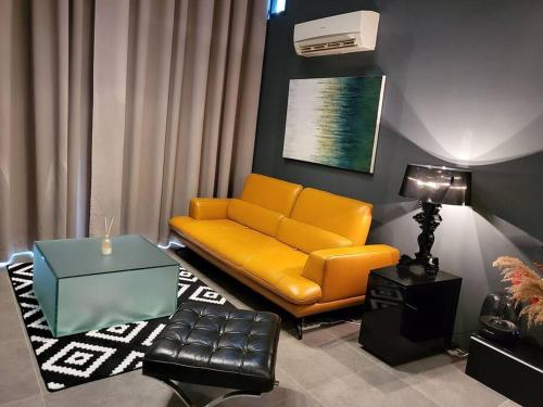 八打灵再也Empire Damansara Designer Soho Karaoke & Netflix的客厅配有黄色的沙发和桌子