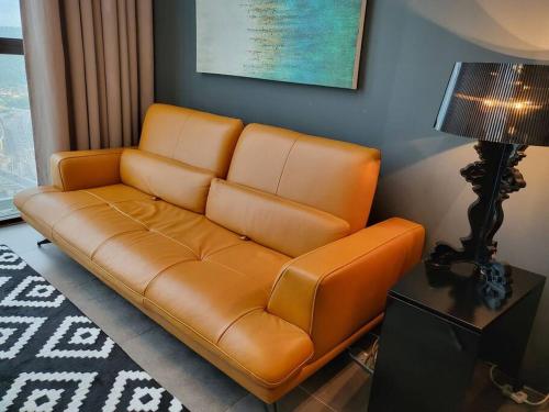 八打灵再也Empire Damansara Designer Soho Karaoke & Netflix的客厅里一张棕色的皮沙发,配有灯