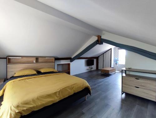 CazèresVilla Garona avec billard proche Pyrénées的阁楼卧室配有一张黄色大床