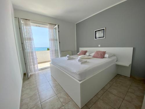 诺瓦利娅Emanuela 1的一间白色的卧室,配有一张享有海景的床