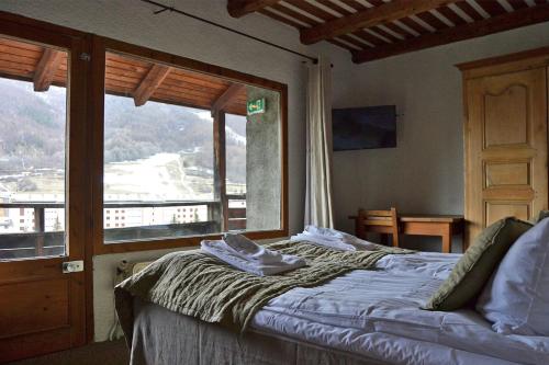 拉萨尔莱阿尔佩兰利老农庄酒店的一间卧室设有一张床和一个大窗户