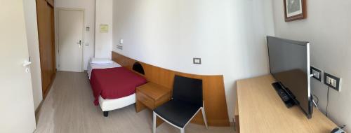 里米尼Hotel Morolli的小房间设有一张床和一张书桌