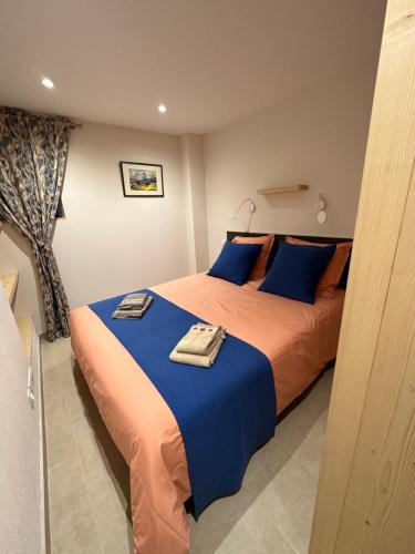 圣热尔韦莱班Residencecalou的一间卧室配有两张蓝色和橙色床单