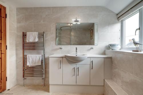 比斯特Meadow Cottage的白色的浴室设有水槽和镜子