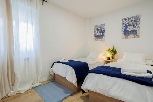 马德里GENESIS APARTMENT IN MADRID的一间卧室设有两张床和窗户。