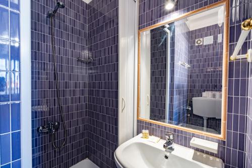 米尔芳提斯城Apartamentos Pátio Victória by Umbral的蓝色瓷砖浴室设有水槽和镜子