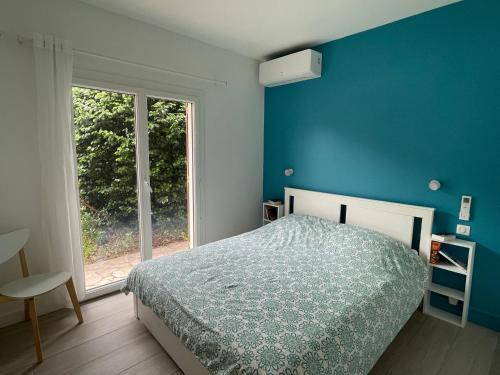 安德诺莱斯贝恩Villa au calme avec piscine, grand jardin et studio indépendant的一间卧室设有一张床和蓝色的墙壁