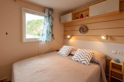 耶尔Le Photinia, mobil-home climatisé avec vue mer situé au cœur du domaine的一间小卧室,配有床和窗户