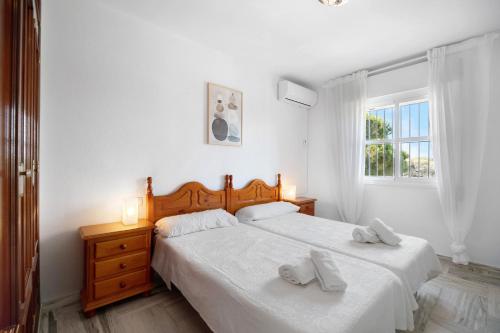 奇克拉纳－德拉弗龙特拉Virgen del Camino 1a línea de playa的一间白色卧室,配有两张床和窗户
