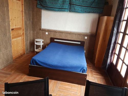 Ossagesstudio Ossages的一间卧室配有一张带蓝色床单的床和两把椅子