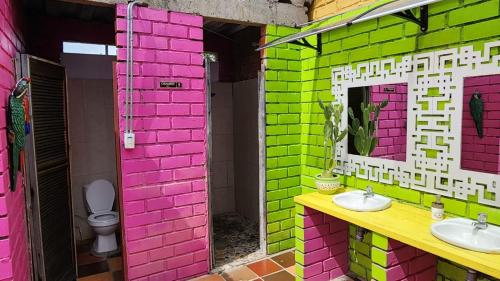 比利亚维哈Dunas Tatacoa的粉红色和绿色的浴室设有卫生间和水槽