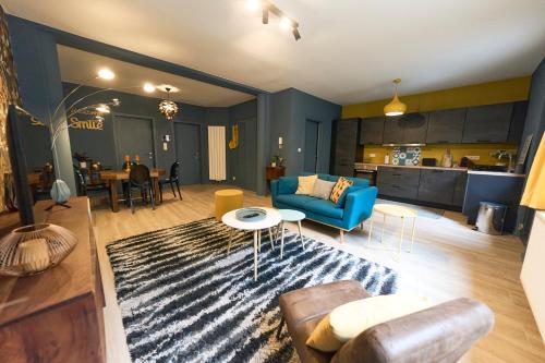 蒙斯Le Vintage coup de coeur !的客厅配有蓝色的沙发和地毯。