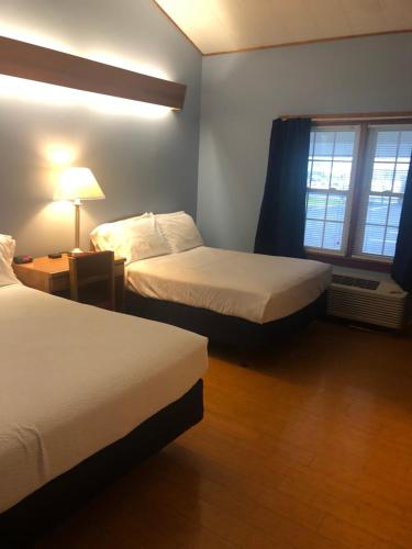 旧奥查德比奇Executive Motel的酒店客房设有两张床和窗户。