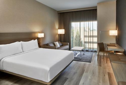 达拉姆AC Hotel by Marriott Durham的一间带白色大床的卧室和一间客厅