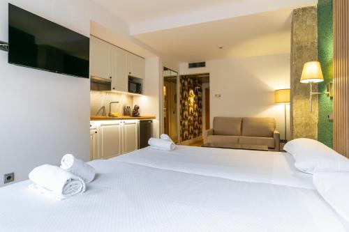 马德里H-A Aparthotel Hotel Quo的酒店客房设有一张白色大床和一张沙发。