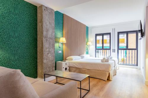 马德里H-A Aparthotel Hotel Quo的酒店客房,设有两张床和一张沙发