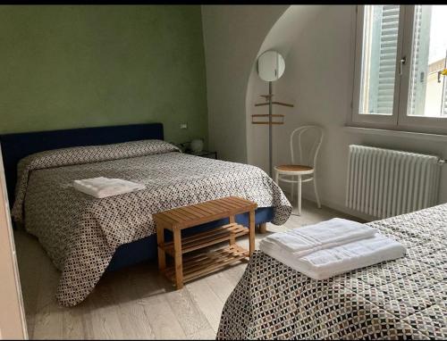 贝加莫RUBY HOME Città Alta的一间卧室配有两张床,中间配有一张桌子