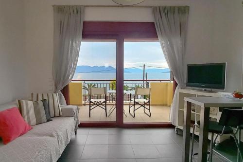 爱琴娜岛A balcony of Aegina by the saronic gulf的带沙发和电视的客厅以及阳台。