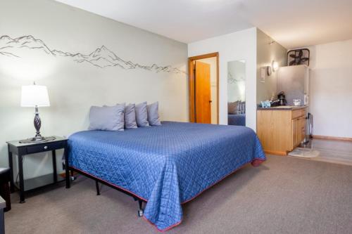 帕尔默先锋汽车旅馆的一间带蓝色床的卧室和一间浴室