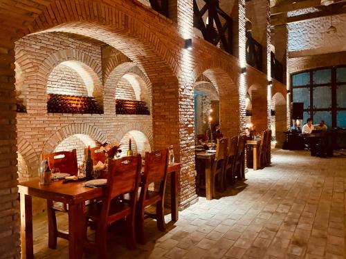 AkhalsopʼeliJavakhishvilebis Marani的餐厅拥有砖墙和桌椅