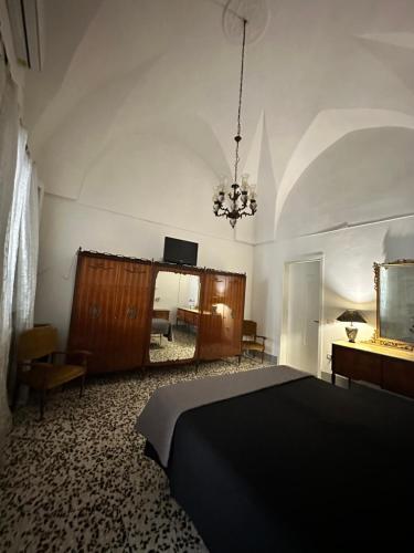 纳尔多MiMì House的一间卧室配有一张黑色的床和吊灯。