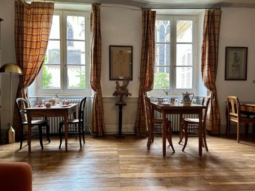 拉沙特尔Maison Harmonie的用餐室设有2张桌子和2个窗户