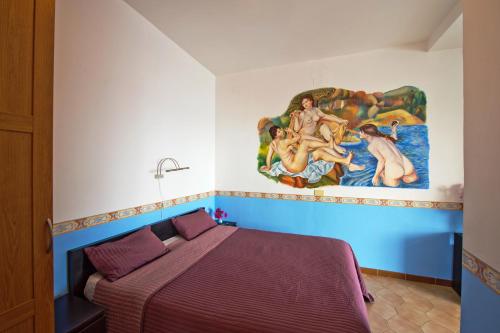 康加德马里尼克劳迪奥住宿加早餐酒店的卧室配有一张床,墙上挂有绘画作品
