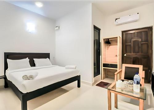 卡兰古特Calangute Turista的白色卧室配有床和桌子