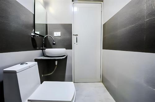卡兰古特Calangute Turista的一间带卫生间、水槽和镜子的浴室