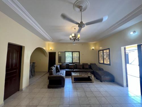 巴马科Villa Saran的带沙发和吊扇的客厅