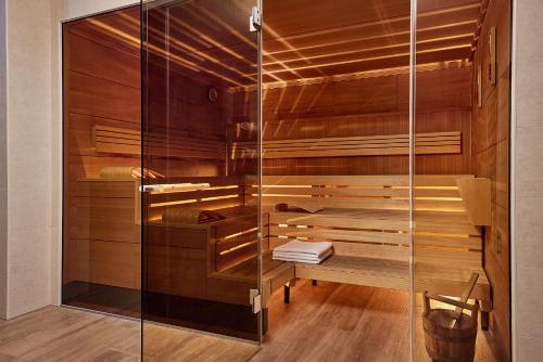 因斯布鲁克因斯布鲁克万豪AC酒店 的一间设有木墙和玻璃门的桑拿浴室