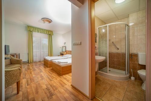 迈泽克韦什德Nefelejcs Hotel的配有床、淋浴和盥洗盆的浴室