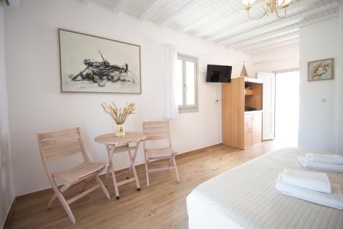 米克诺斯城Crystal View Mykonos的白色的客房配有桌椅和一张床