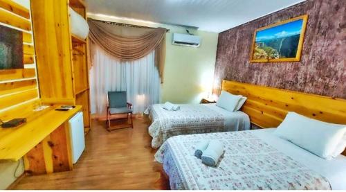 坎巴拉Pousada Encanto dos Cânions的酒店客房配有两张床和一张书桌